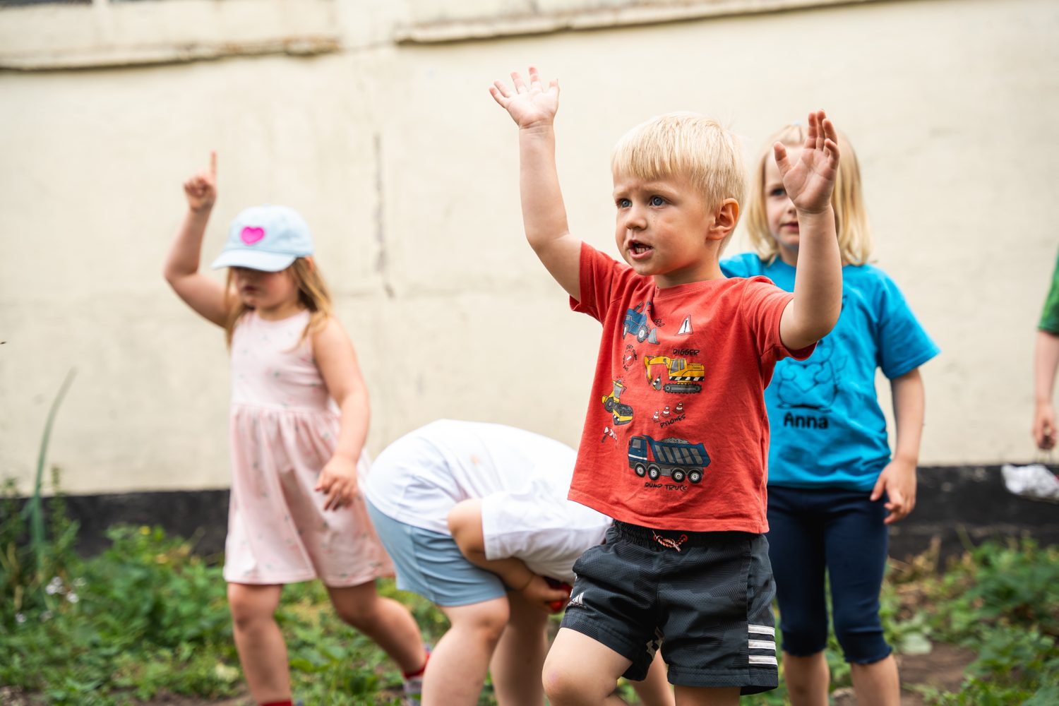 Kinder heben am Beet die Hände und melden sich